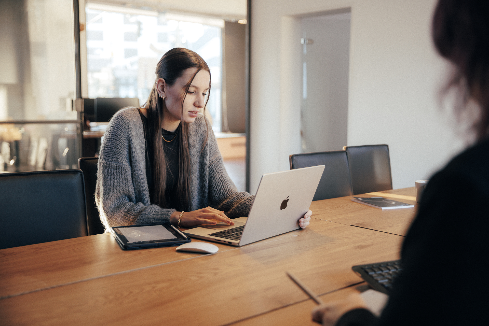 Zwei Personen sitzen nachdenklich vor je einem Laptop