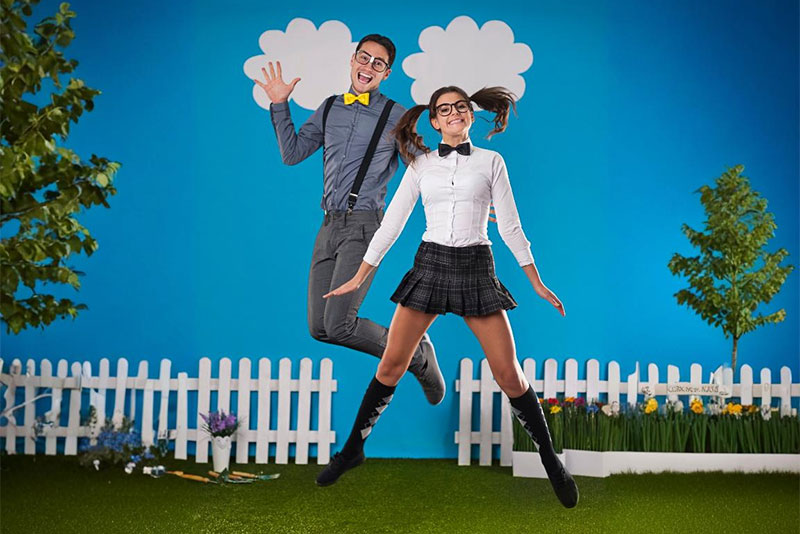 Zwei Personen, die auf einer Grasfläche fröhlich hochspringen