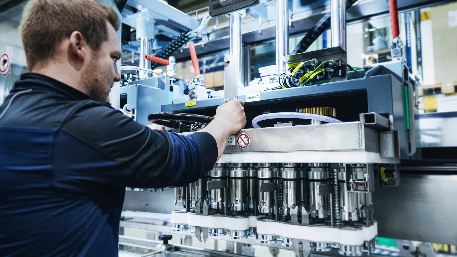 Ein Monteur schraubt an einer Entkorkermaschine