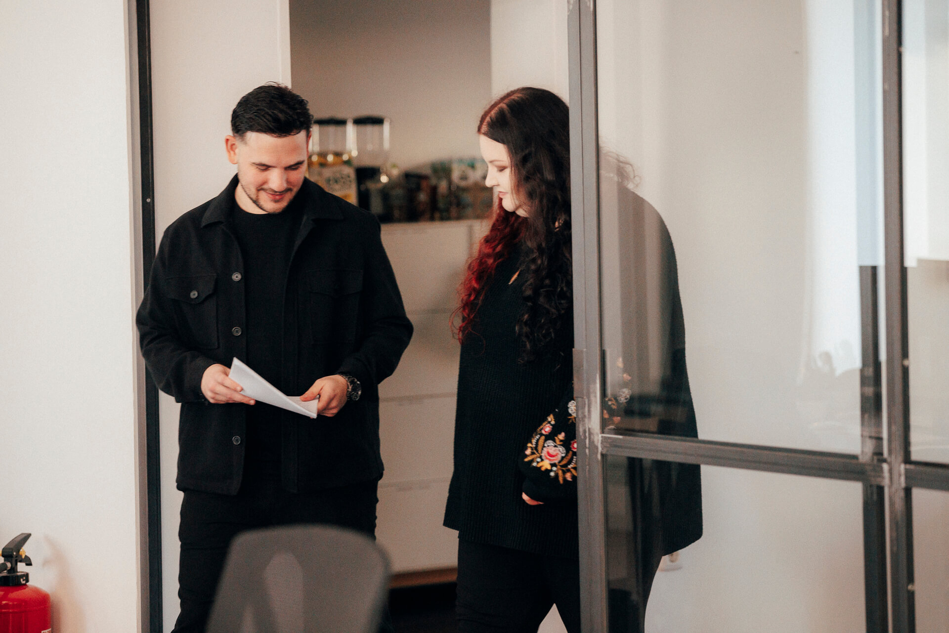 Zwei Personen schauen sich Text auf einem Blatt Papier an