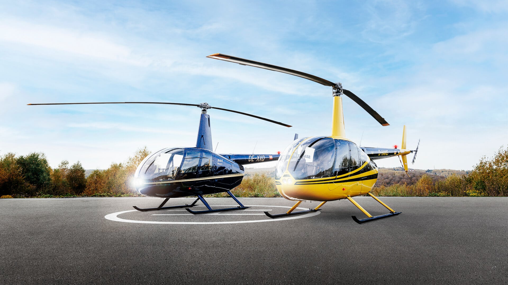 Zwei Hubschrauber auf einem Landeplatz vor blauem Himmel