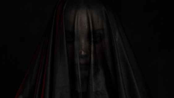 Person, die von einem schwarzen Tuch bedeckt ist. Symbolbild für Cloaking im Black Hat SEO.